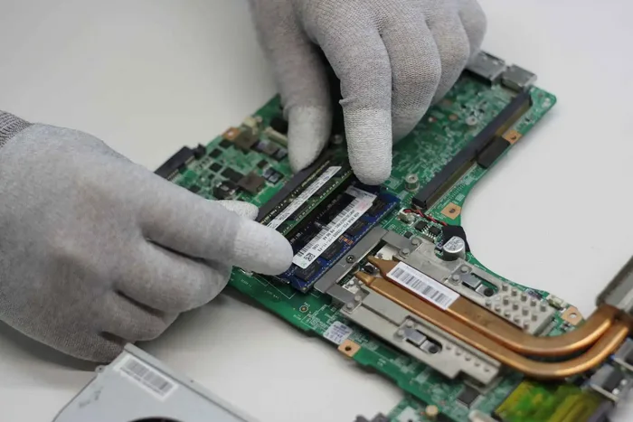 Student's laptop open on a desk during a repair check