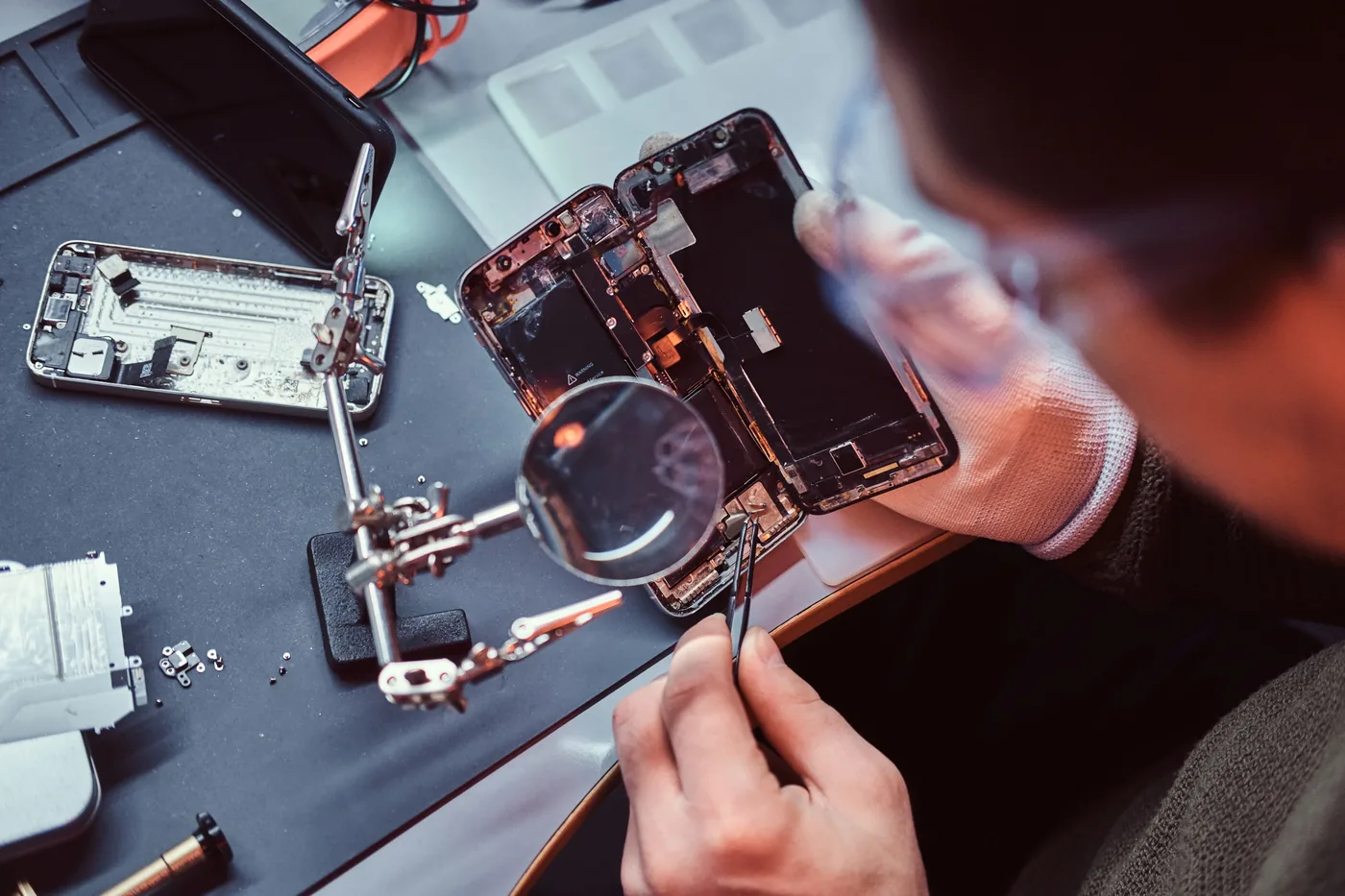 A technician repairing the internal components of a smartphone